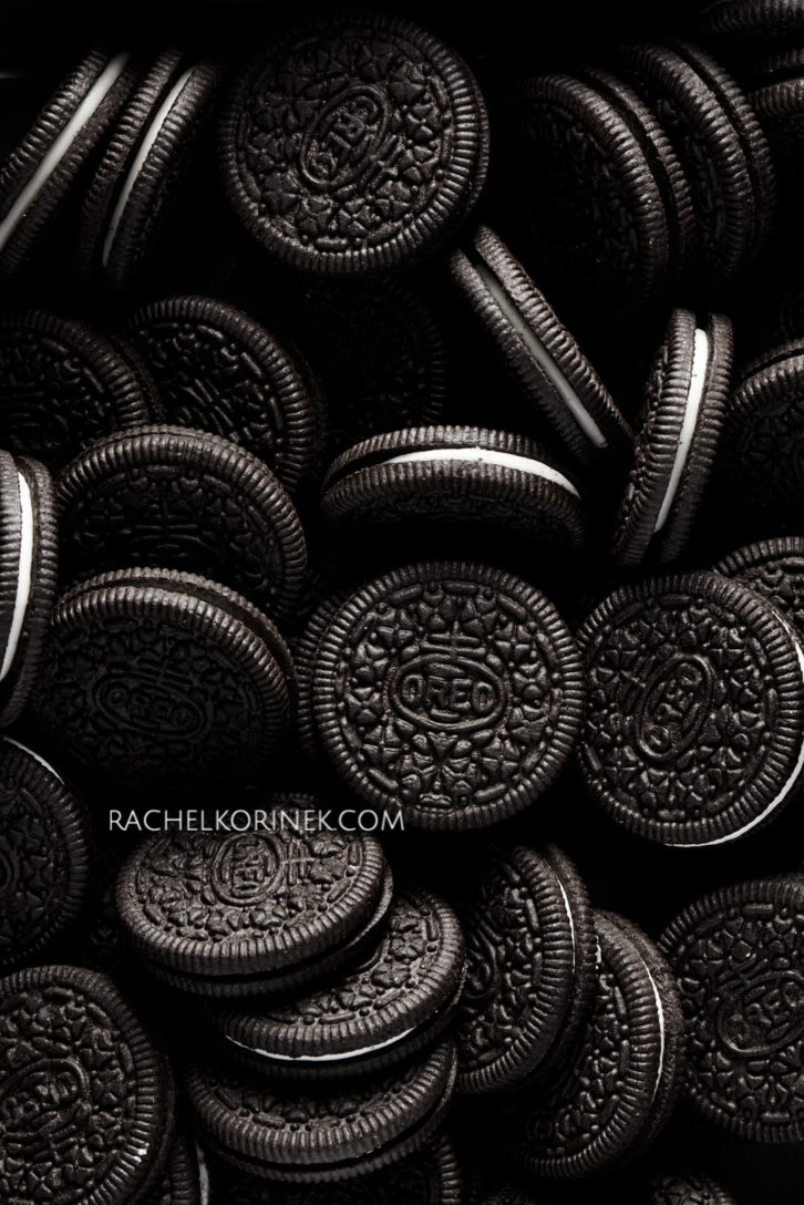 Lots of oreo cookies in dramatic lighting. There isn't any colour to this photo so it appears black and white even thought it's real food!