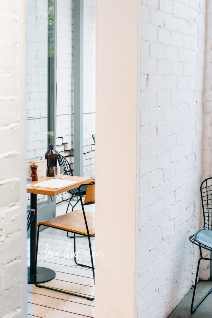 An empty table at a cafe. You can only see part of the table between a doorway.