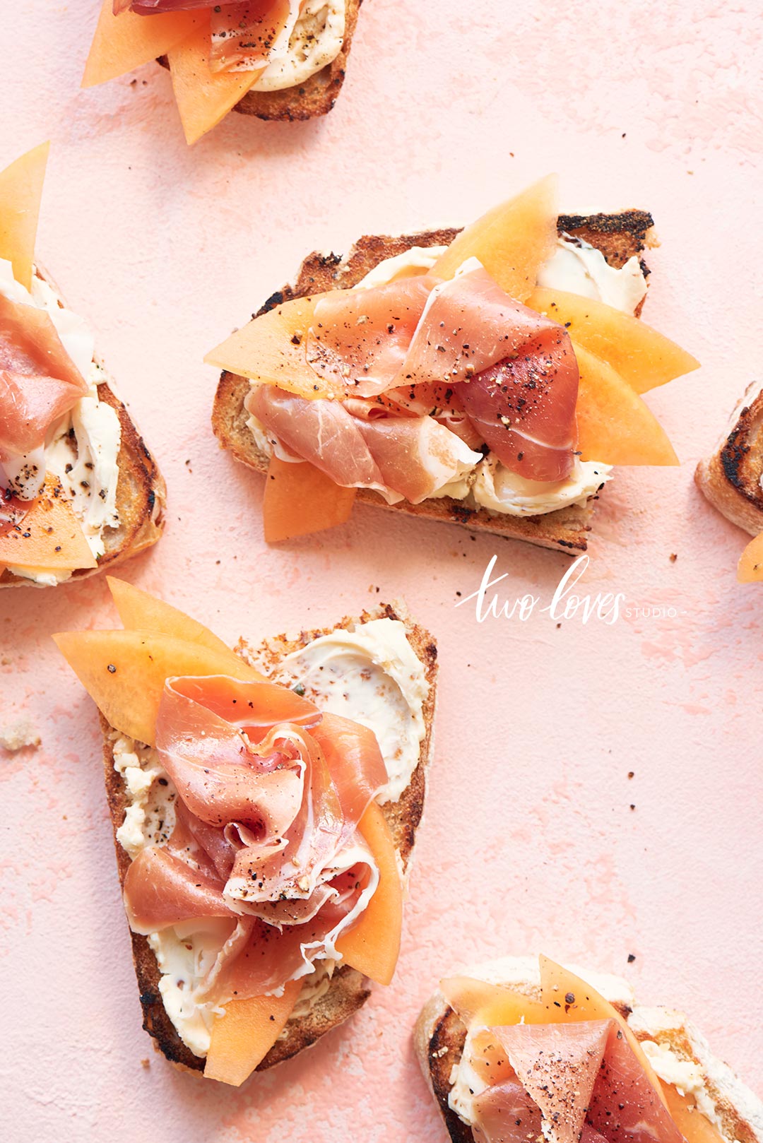 Pink backdrop with toast creme cheese with salmon topping. 