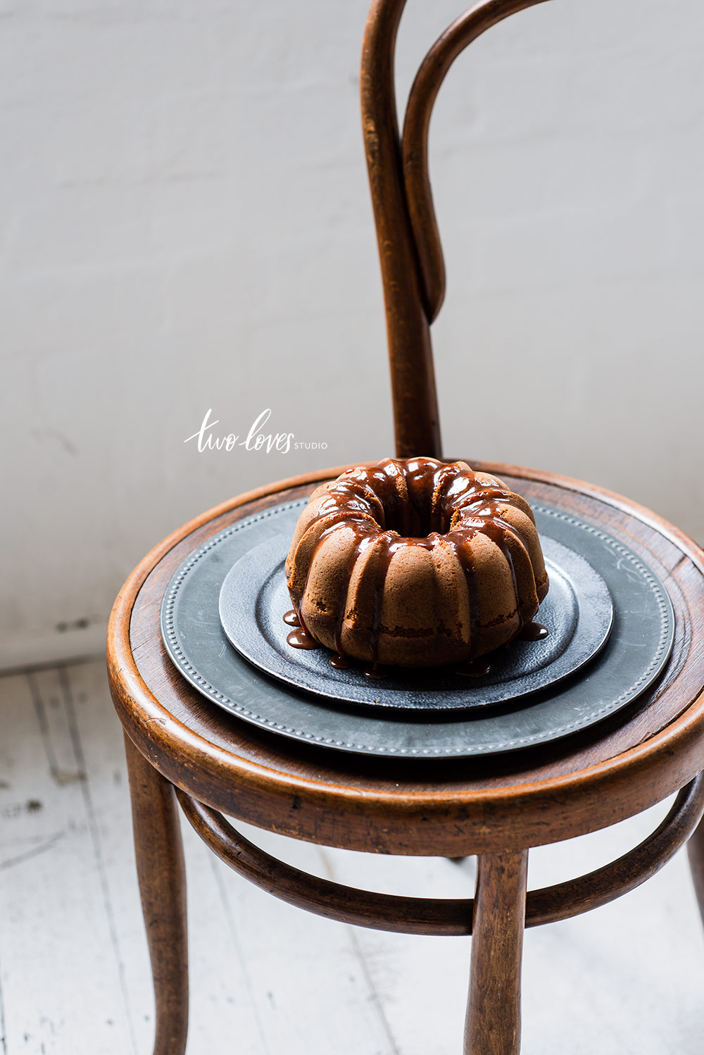 A bunt cake on top of a chair and a dark plate. 