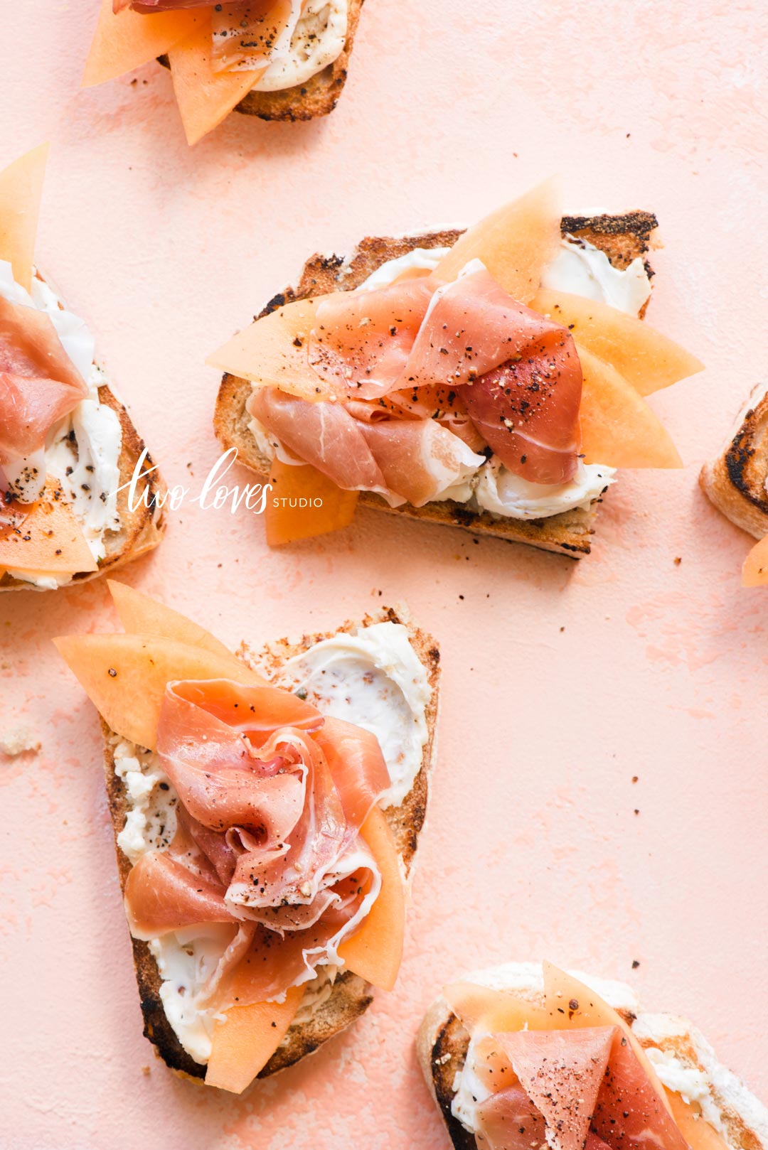 Pink backdrop on slices of toasted slices of bread with cream cheese and smoked salmon. 