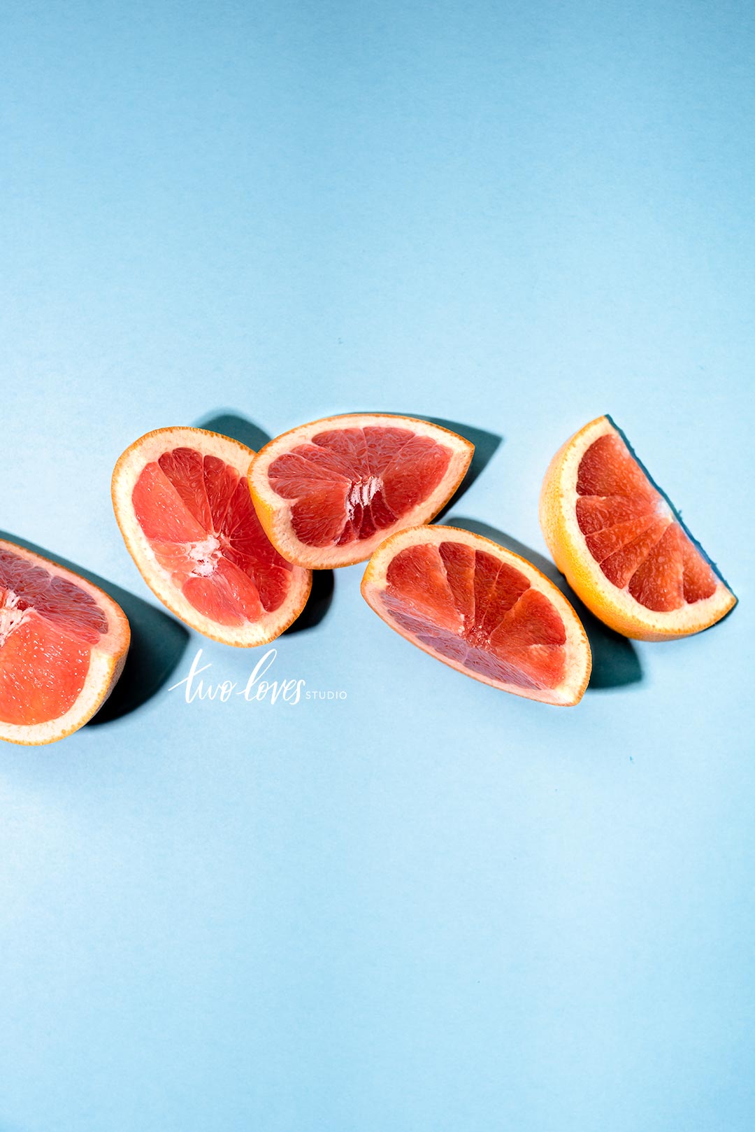 Oranges slices placed in an arrangement on a blue background. 