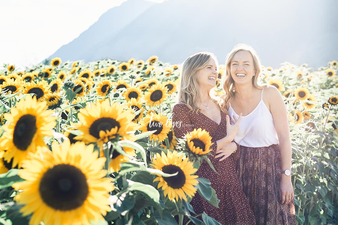 Rachel and her sister posing in a sunflower field. 