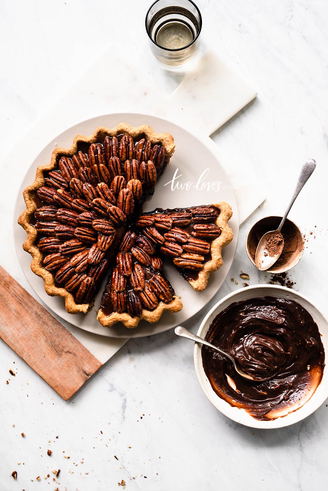 A pecan pie cut into slices on a white plate