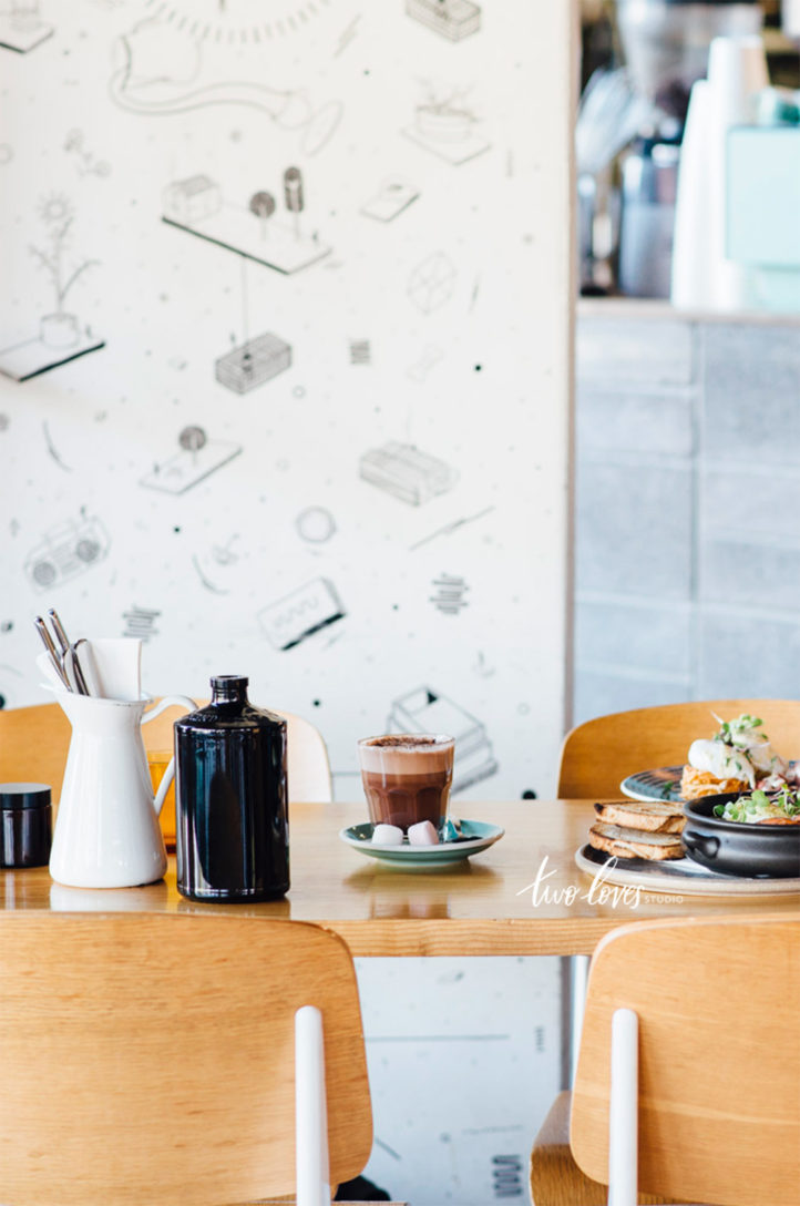 A table with a coffee and some other dishes in a cafe setting. 