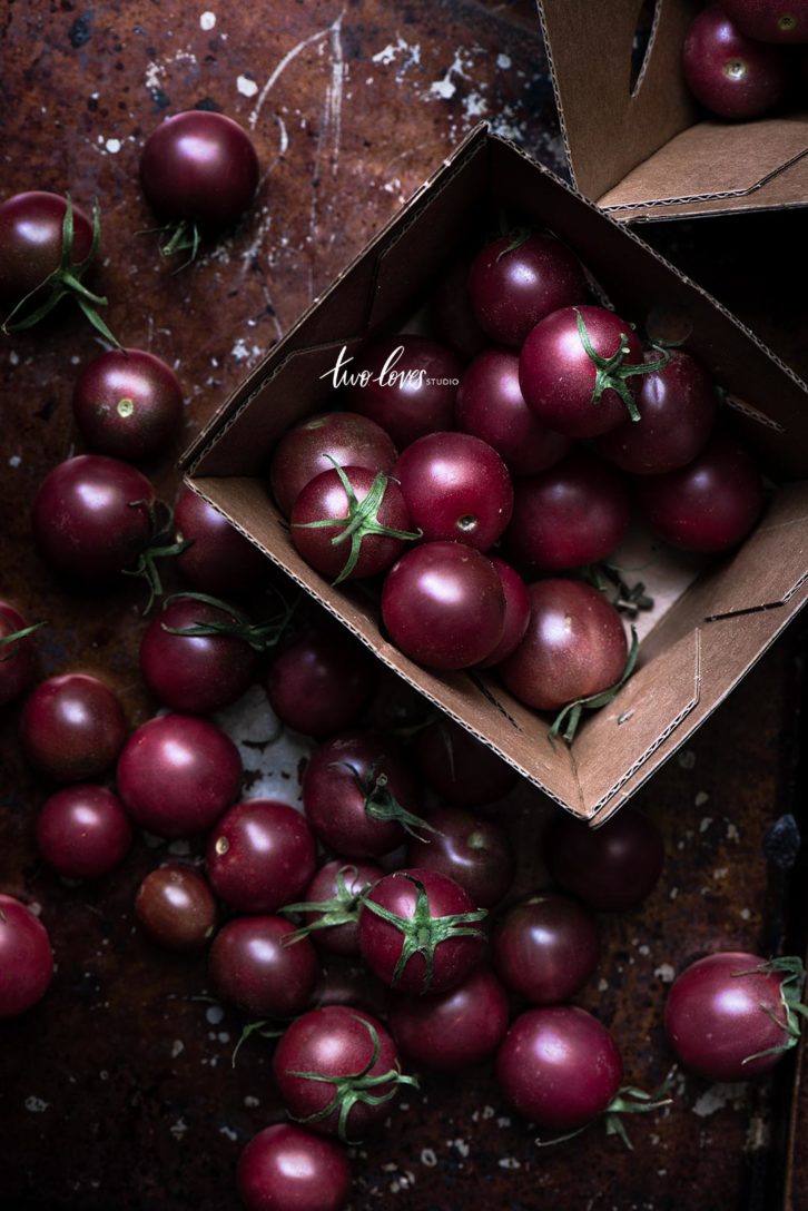 A brown box with deep red tomatoes inside. 