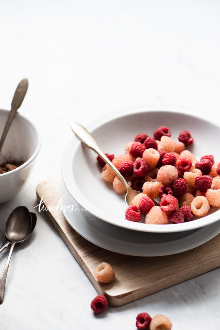 A bowl of raspberries, red and yellow with side light.