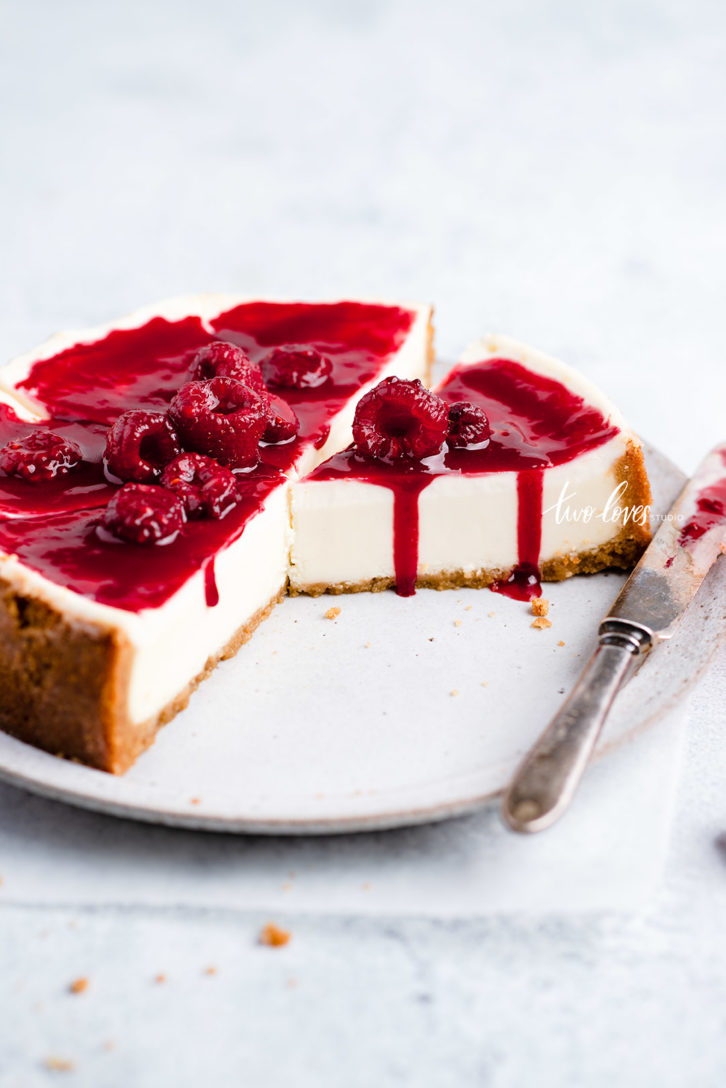 A cheesecake with raspberries on top. 