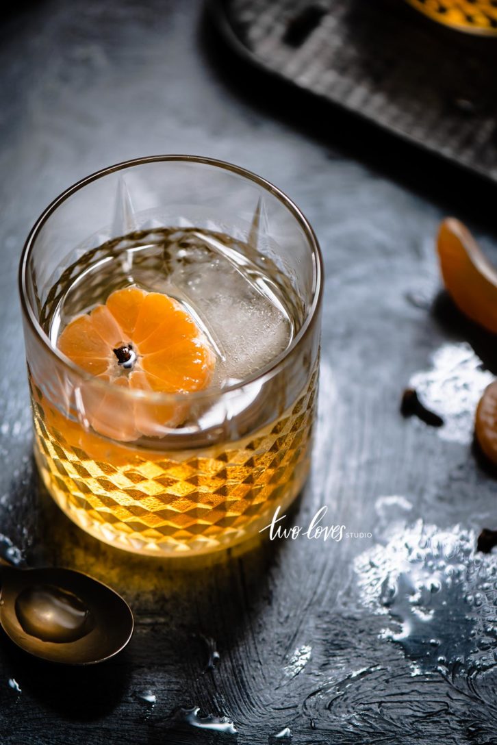 A cocktail glass with a clementine 