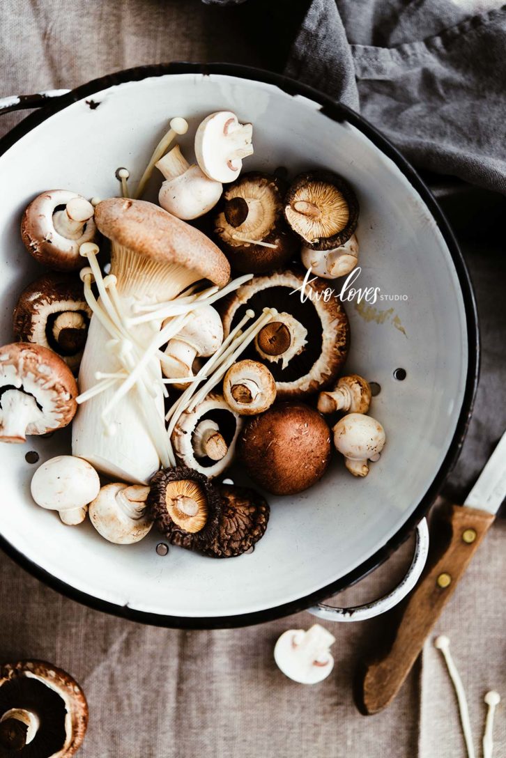 An assortment of different mushrooms in a bowl.