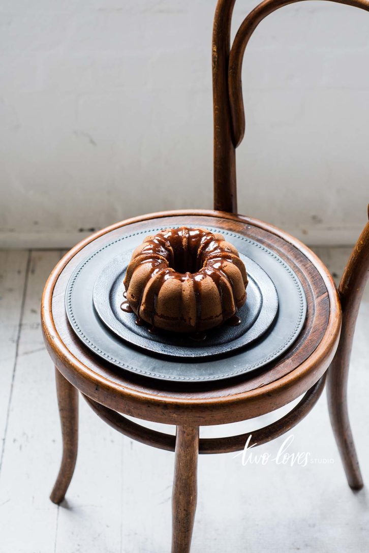 A small chair with a plate and a bundt cake on top.