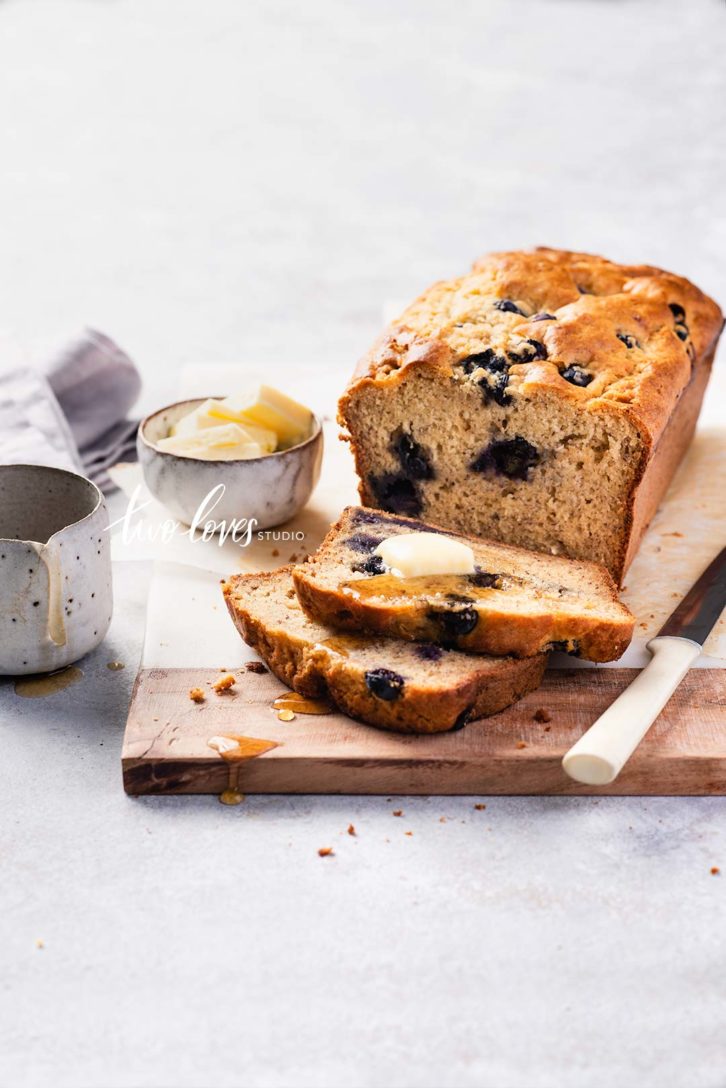 Banana cake with blueberries and a side dish of butter.