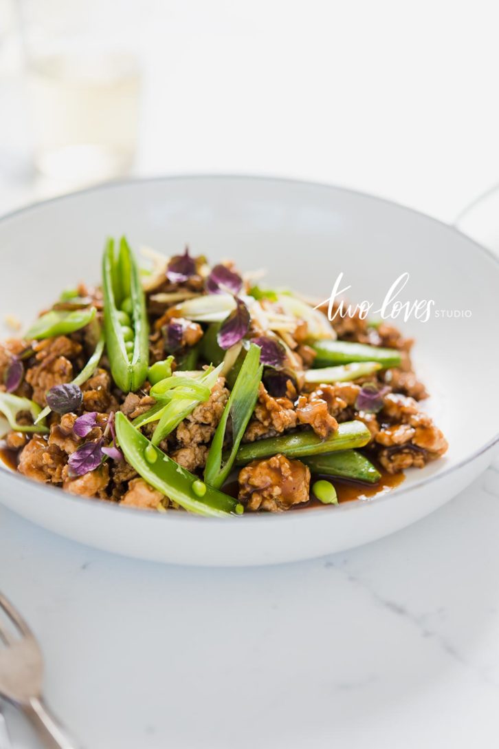 A bowl with a dinner dish and green topping