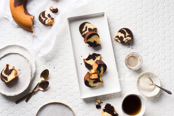 Bundt marble cake cut into slices on a white backdrop.