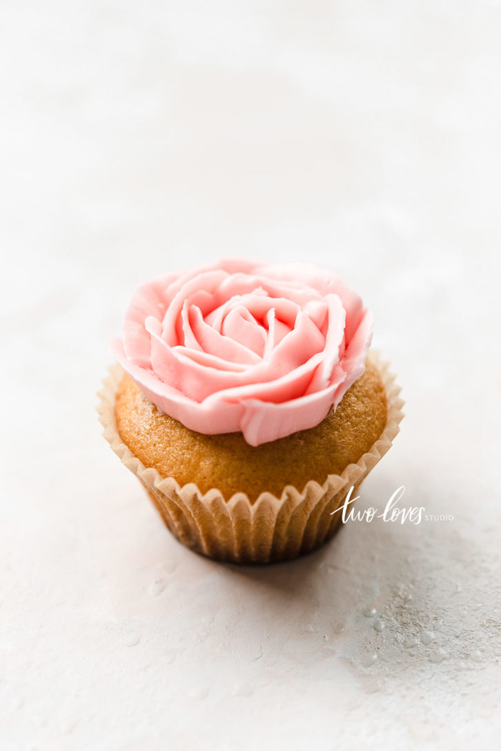 Cupcake with a pink flower piped on-top.