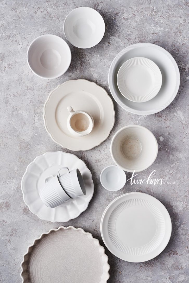 White collection of props of plates and bowls and cups.