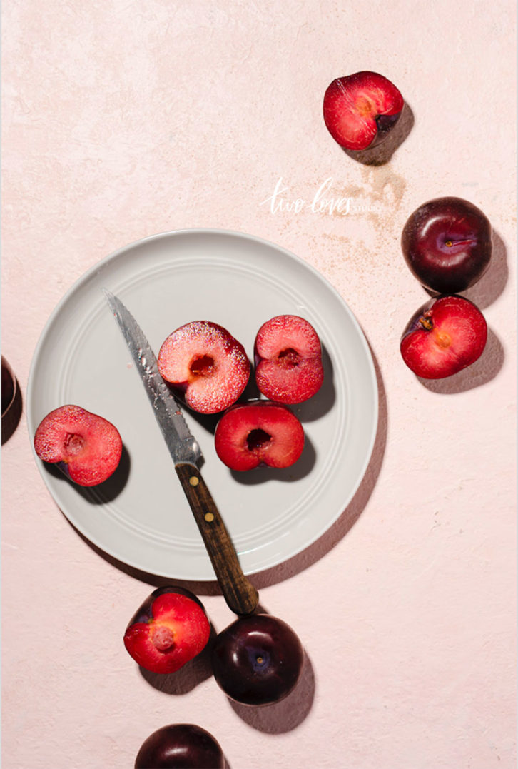 Stone fruit cut in half on a white plate