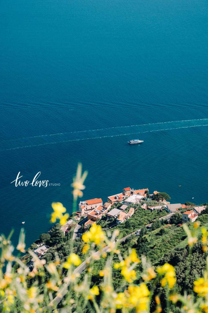 An areial view of a boat traveling along blue water in Italy.