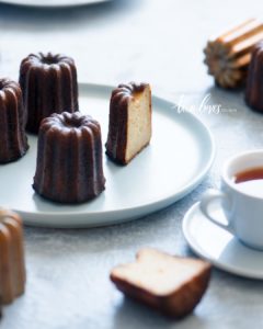 Four caneles cakes and a cup of tea.