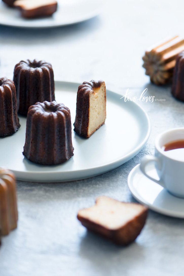 Four caneles cakes and a cup of tea.