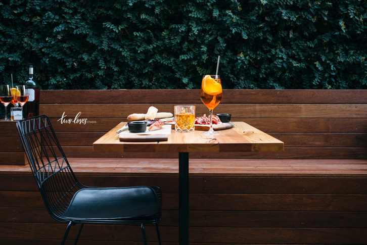 Appetizers and drinks on a table in a patio outdoor setting. 