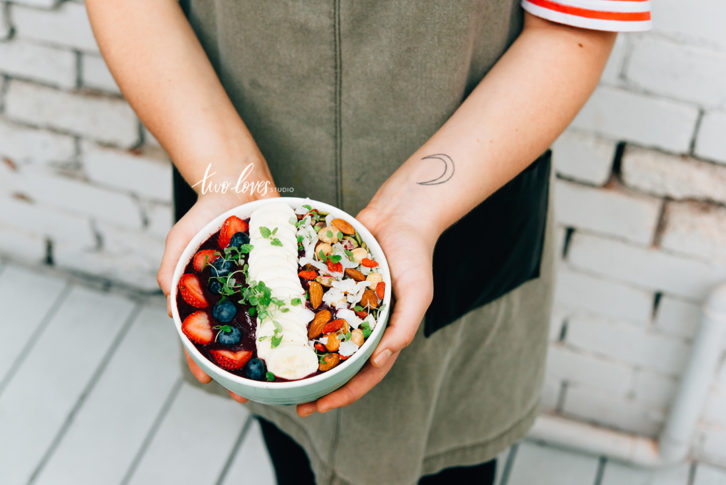 Smoothie bowl with fresh strawberries, blueberries, an assortment of nuts and acai berries.