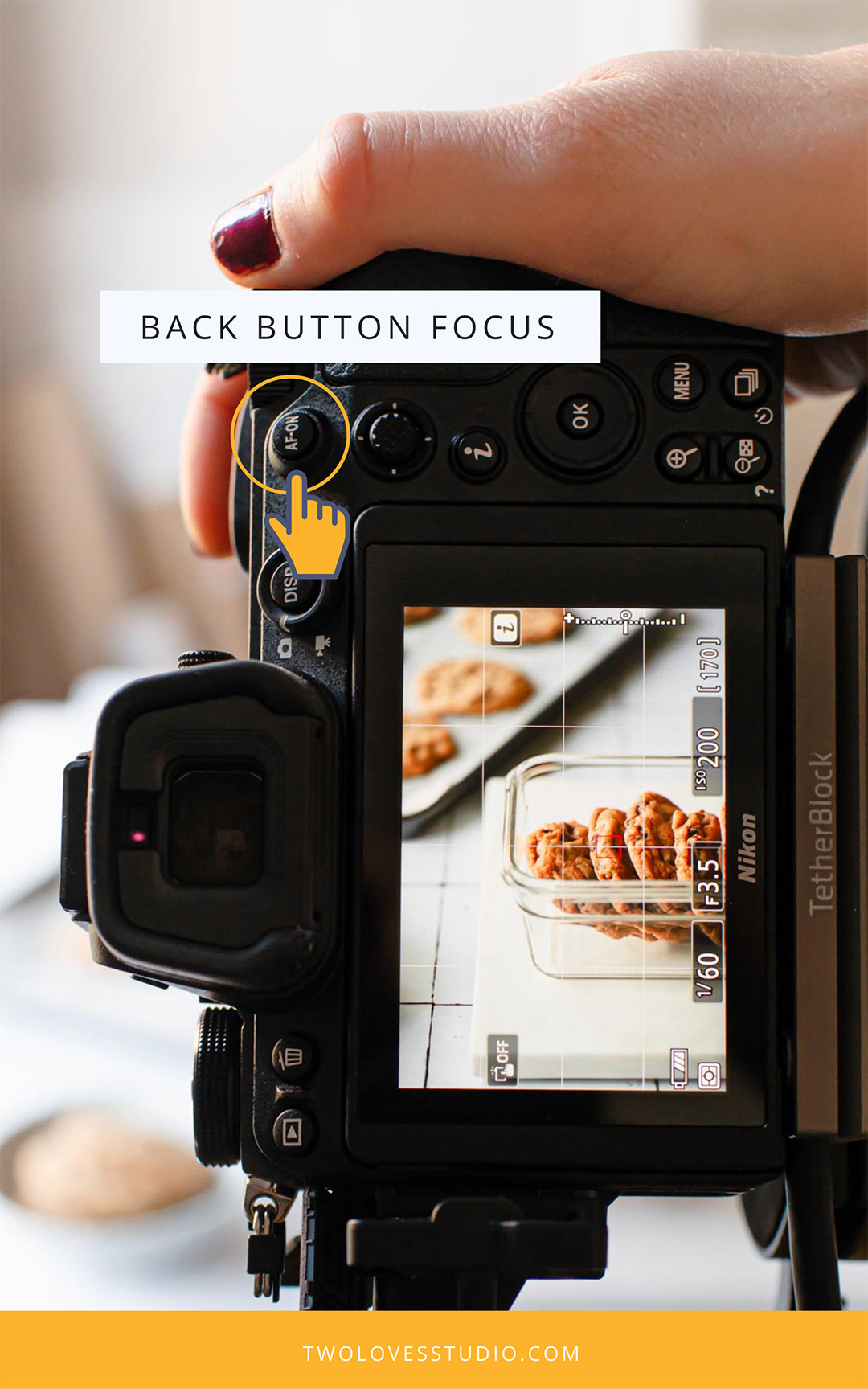 Glass dish filled with cookies on a white surface through the view finder on the back of a camera. 