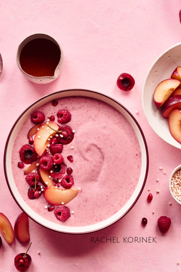 Pink berry smoothie bowl with berry and fruit garnish. White balance in this shot shows a warmer shot.