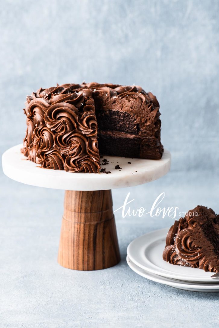 A chocolate swirl cake with a slice cut out on a plate.