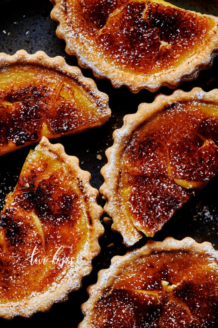 Up close shot of lemon tarts that have been bruleed. Cut in half.