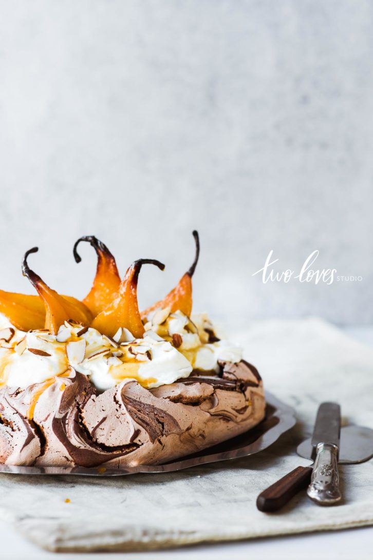 Chocolate swirl pavlova cake with poached pears.