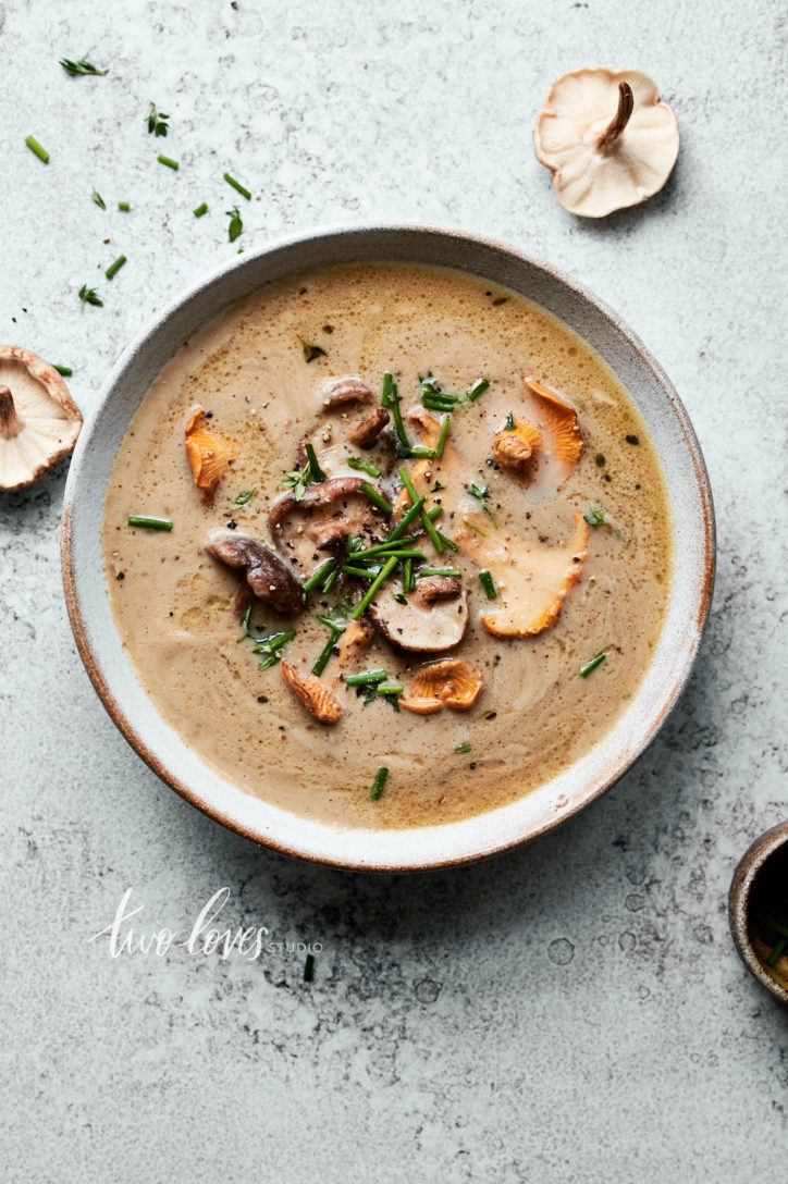 An overhead bowl of mushroom soup with a garnish of lightly fried shiitake and chantrelle mushrooms.