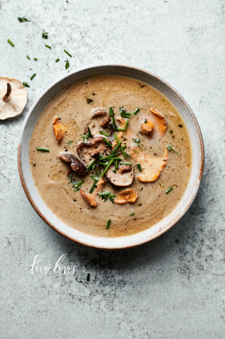 An overhead bowl of mushroom soup with a garnish of lightly fried shiitake and chantrelle mushrooms.