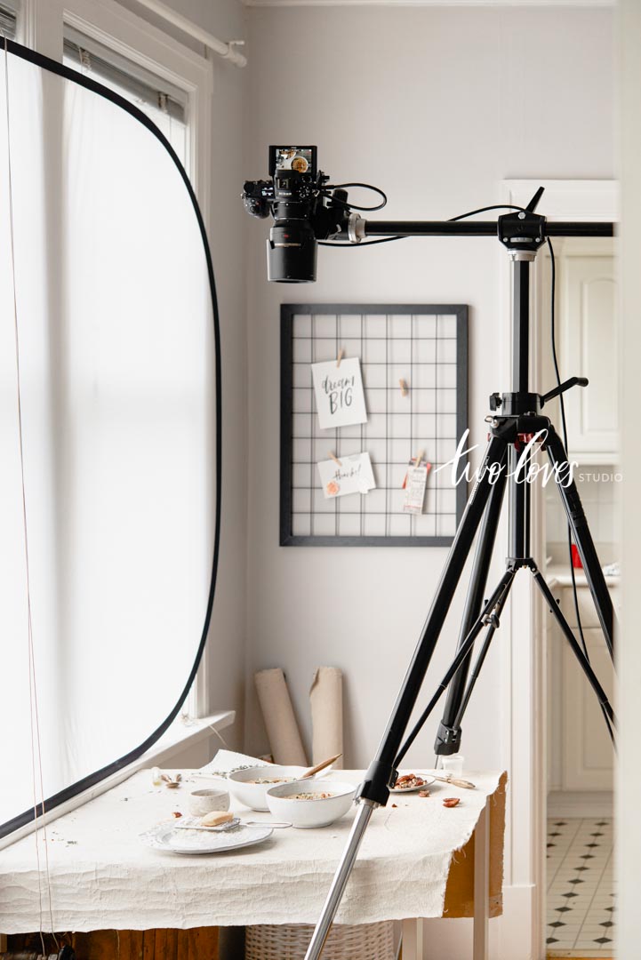 A diffuser diffusing natural light for food photography. A large tripod overhead with cauliflower soup.