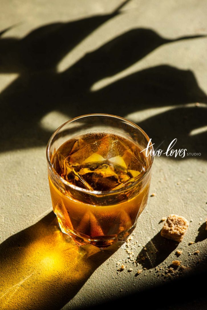 whiskey in a glass with hard lighting and shadow play for natural light food photos.