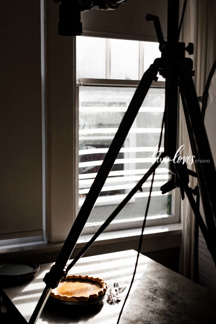 Pumpkin pie behind the scenes food photography setup for natural light with tripod.