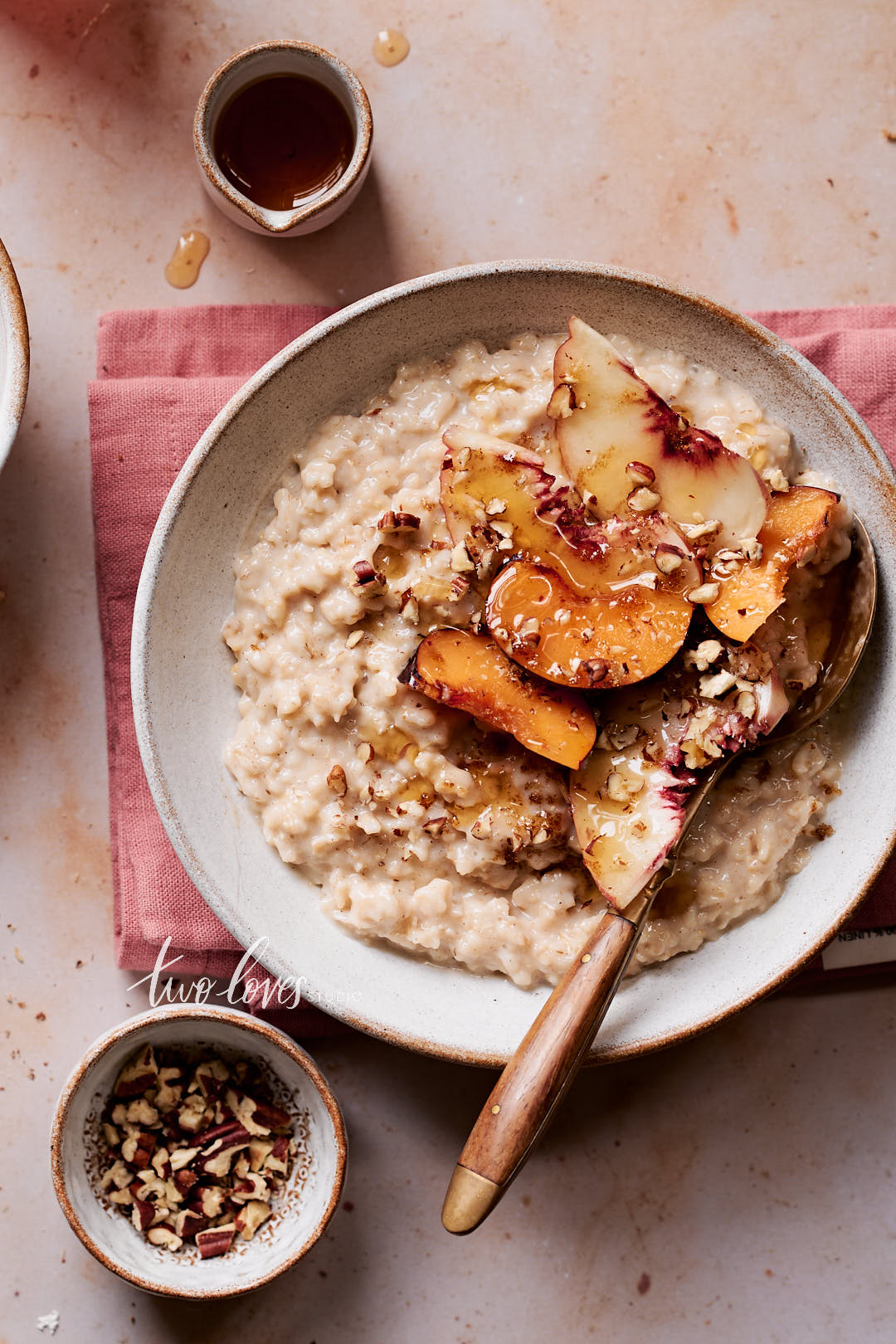 Fresh bowl of oatmeal with nectarines, plums and maple syrup.
