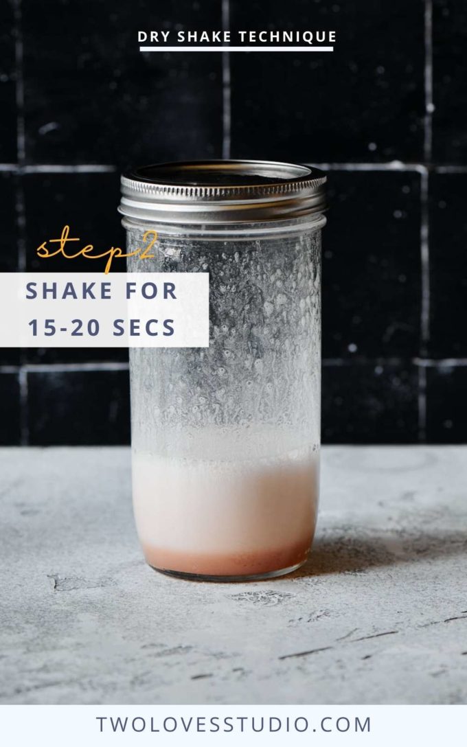 Step by step example. Cocktail liquid in a mason jar on a dark background. With a lid on after a 20 second shake. Foam showing.