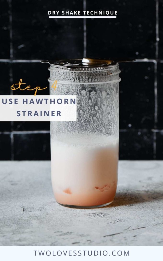 Step by step example. Cocktail liquid in a mason jar on a dark background. with foam forming and a hawthorn strainer ontop.