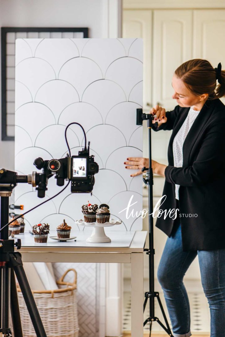 behind the scenes of a cupcake photoshoot with a background and the food photography equipment to capture the shot.