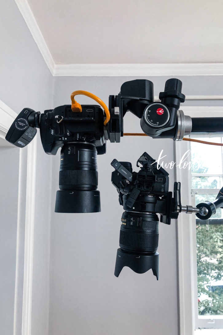 Two black cameras pointing down, each on a z-mount tripod demonstrating the difference between a mirrorless vs dslr camera.