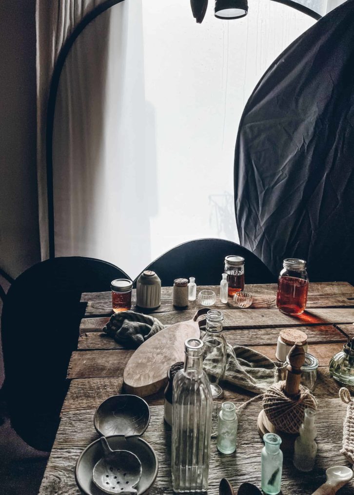 Wooden table with props on top, blocks positioned in the photo to the left of the table, shutting out light. 