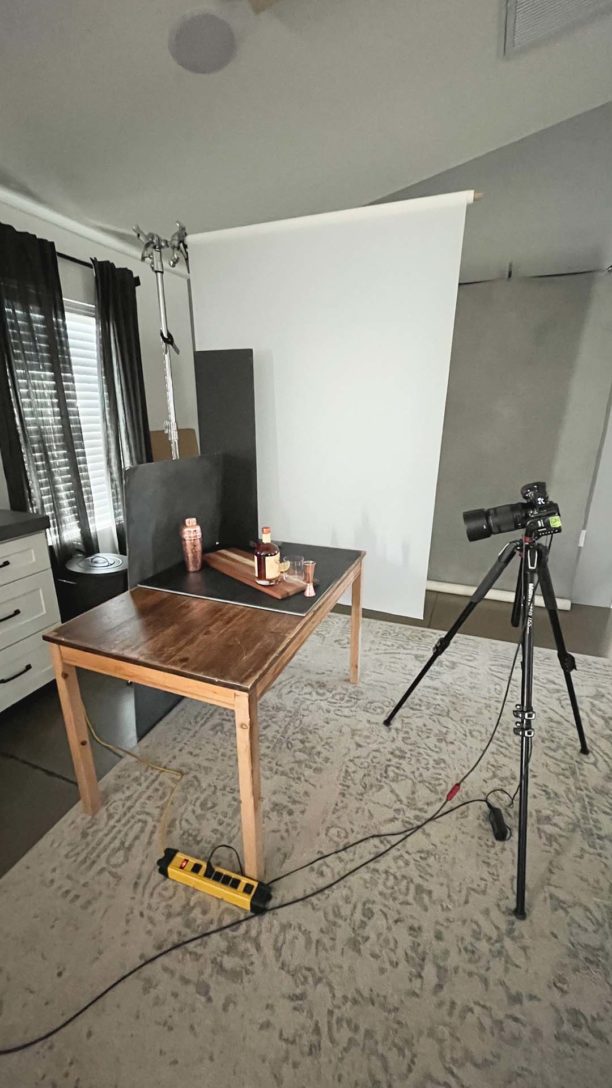 Wooden table with drink props on the table, black foam core positioned at the rear of the shot.