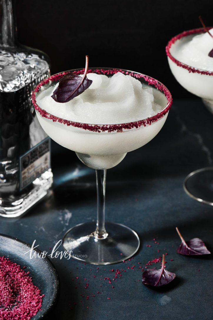 Frozen texture in photography. Large margarita on a dark background with a red salt rim. 