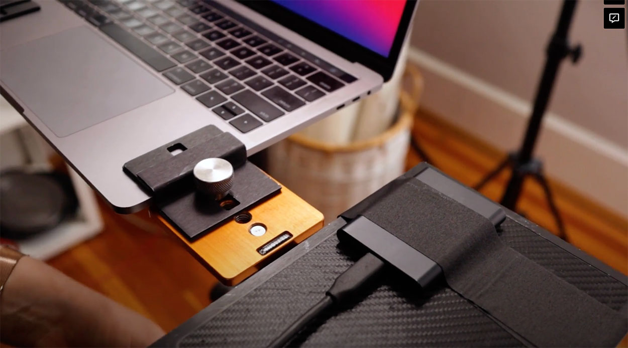 Close up shot showing a laptop sitting next to a harddrive which is being tethered directly to. 