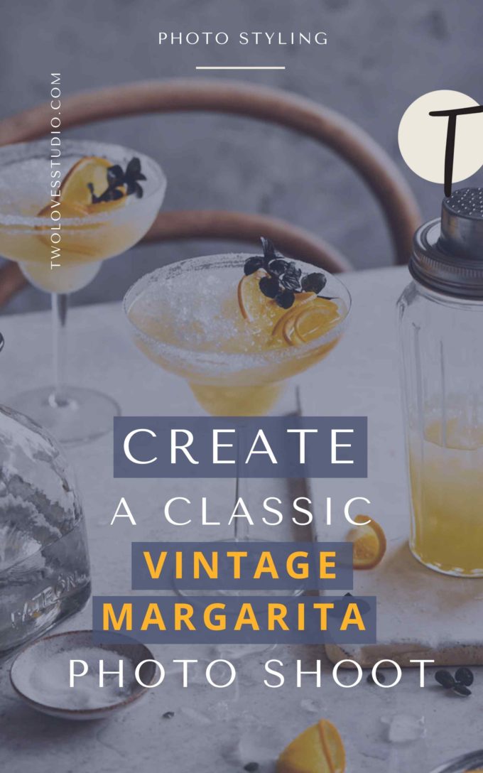 Classic margaritas on a marble backdrop with a cocktail shaker and orange slices.  