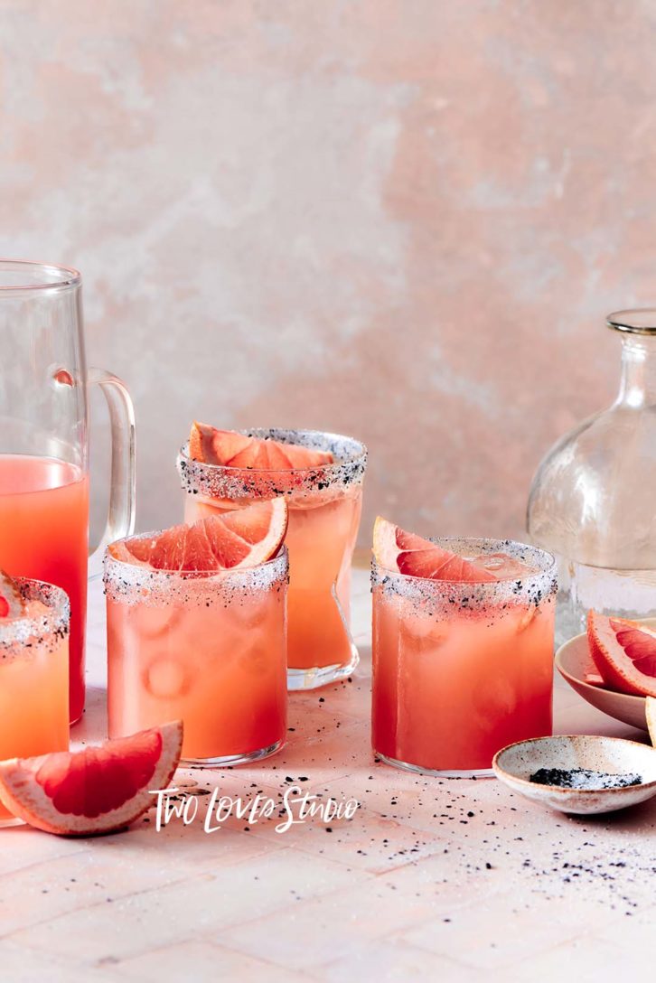 Soft pink titles with blood orange margaritas and black pepper, white salt rims. color techniques.