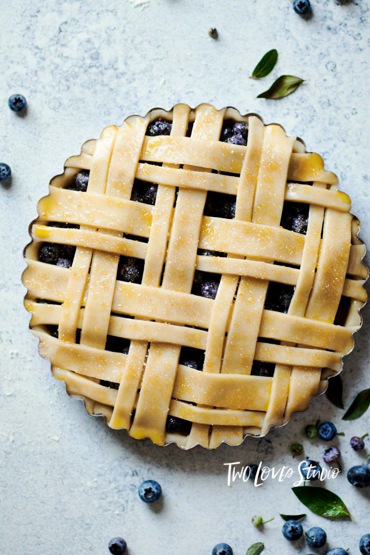 Blueberry pie with a pastry cross-stitch patten on top. 