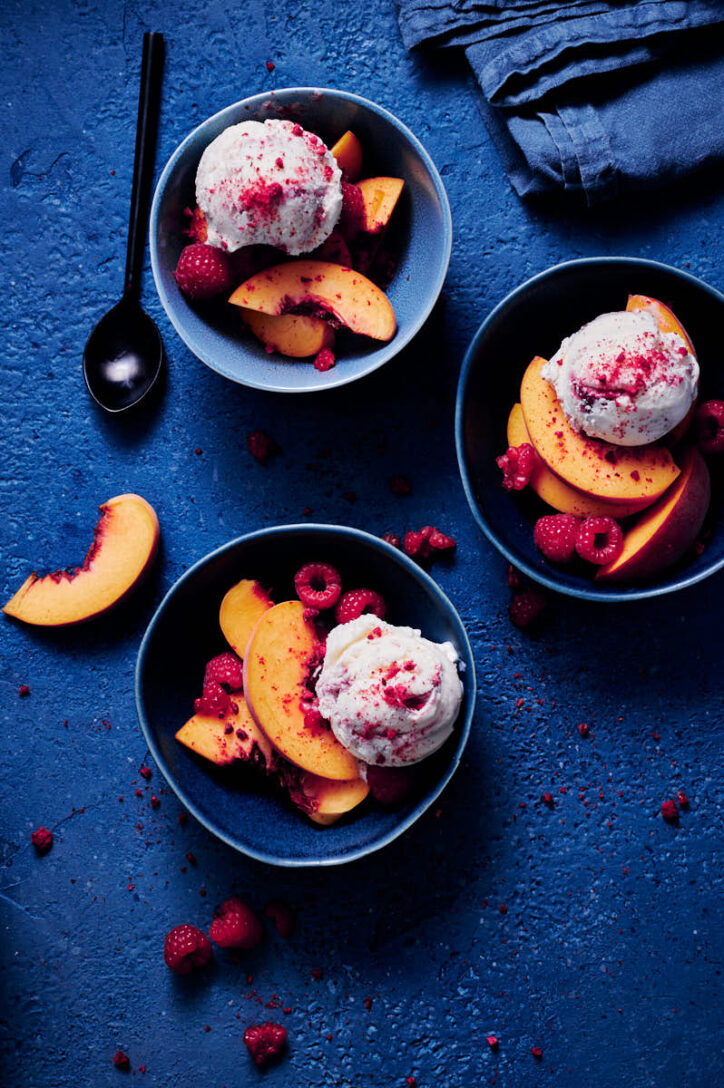 dark blue photography backdrop with peaches in a bowl. 