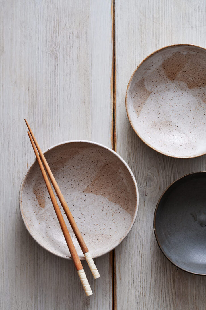 White wooden table with a mixture Japanese bowls and chopsticks